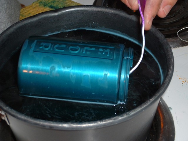 One shaker in a pot of dye on the stove, now teal in color.